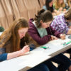 3 invicta students learning chinese calligraphy